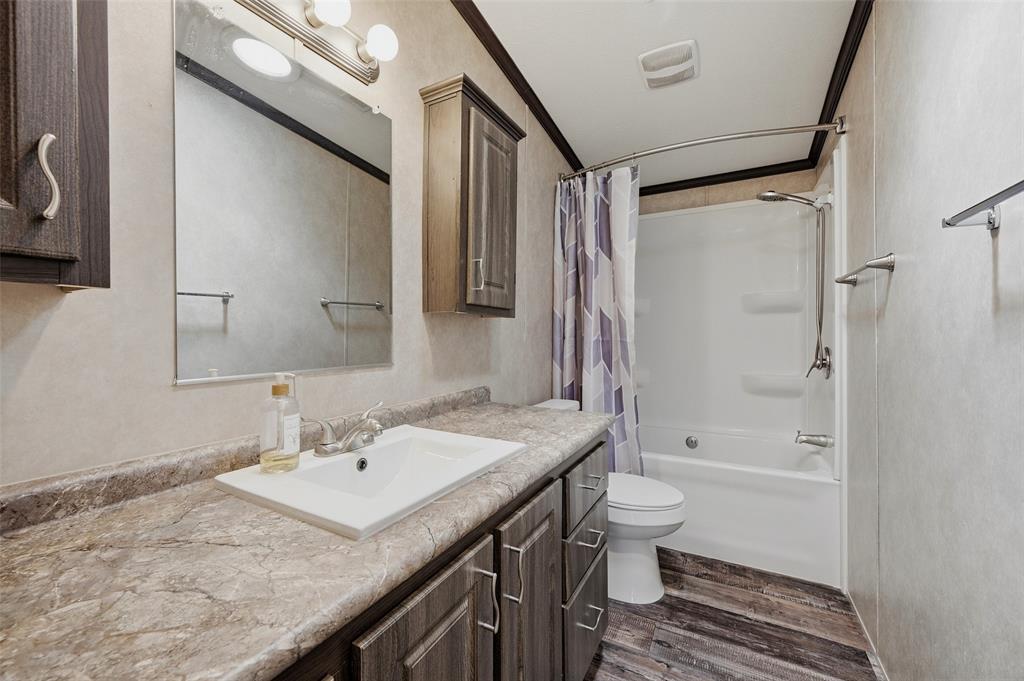 1113 Caroline Court Howe, TX 75459 - Photo 19 of 32 a bathroom with a granite countertop sink toilet and shower