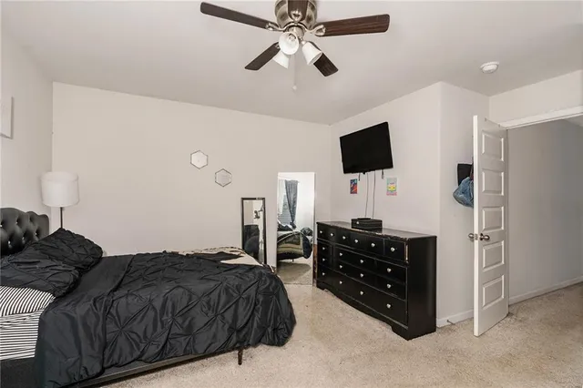 a spacious bedroom with a bed and a flat screen tv