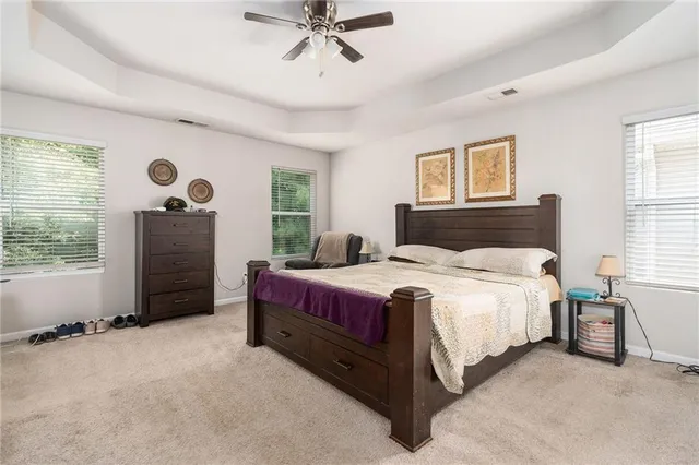 a spacious bedroom with a bed and a chandelier