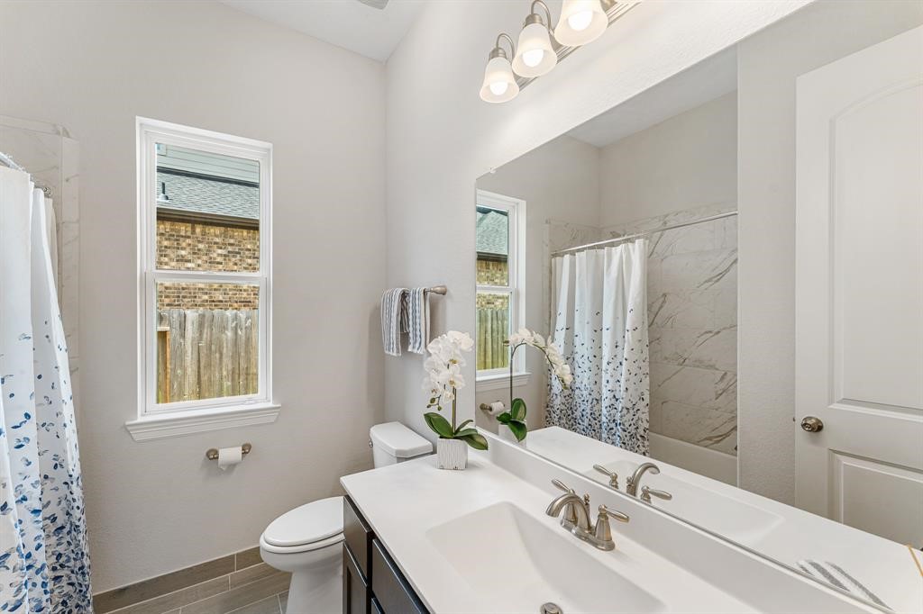 2311 Jitterbug Lane Katy, TX 77493 - Photo 17 of 25 a bathroom with a sink a toilet and a mirror