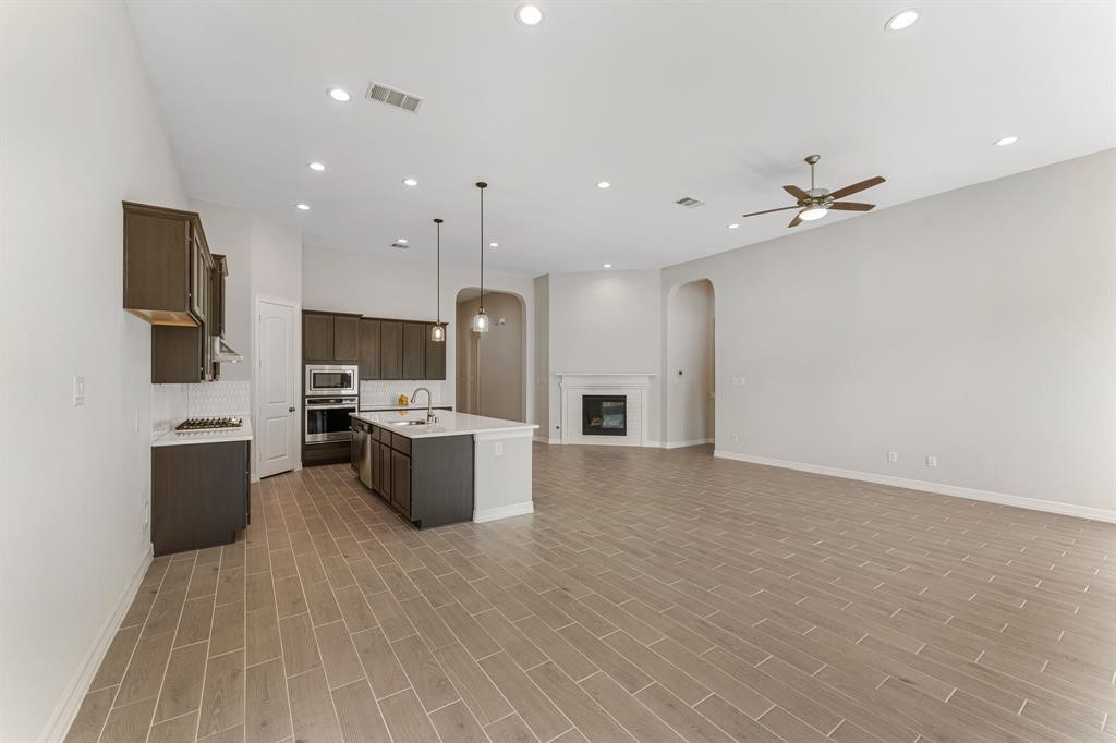 2311 Jitterbug Lane Katy, TX 77493 - Photo 8 of 25 a kitchen with stainless steel appliances kitchen island a stove a refrigerator a sink a microwave a dining table and chairs