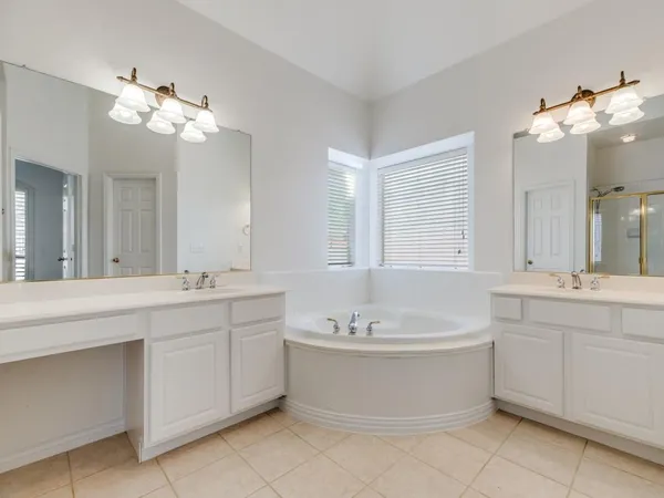 a bathroom with a tub sink and mirror