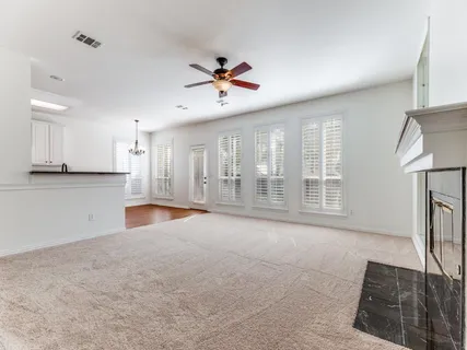 a view of an empty room with a fireplace and a window