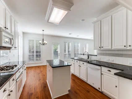 a kitchen with stainless steel appliances granite countertop a sink stove and cabinets