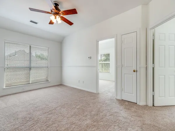 an empty room with closet and windows
