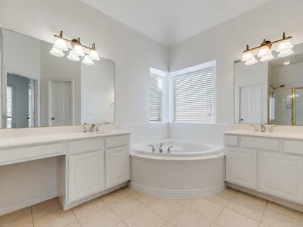 a bathroom with a tub sink and mirror