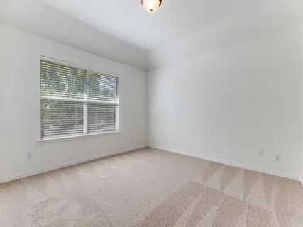 a bedroom with bed and a large window