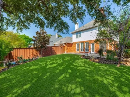 a view of a house with backyard and a tree