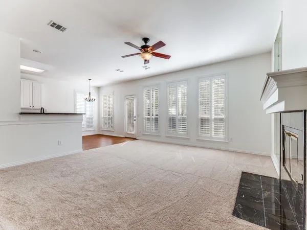 a view of an empty room with a fireplace and a window