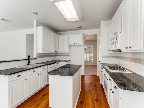 a kitchen with granite countertop stainless steel appliances a stove and a refrigerator