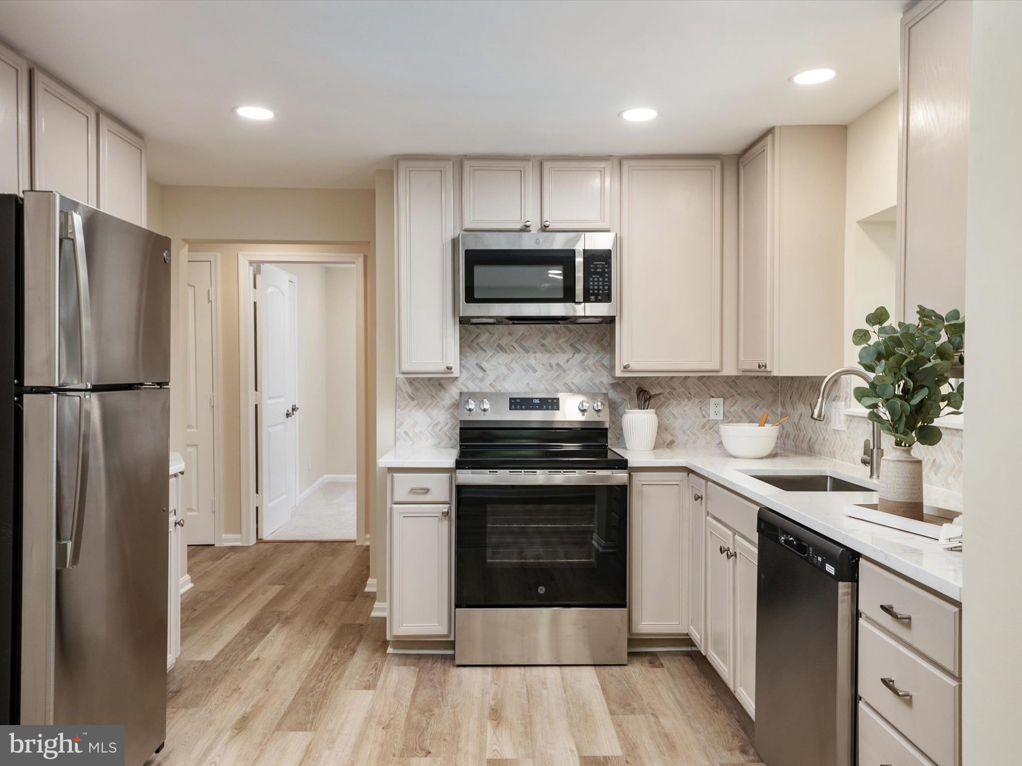 1395 Rainbow Drive Pasadena, MD 21122 - Photo 19 of 28 a kitchen with stainless steel appliances granite countertop a stove a refrigerator and a sink