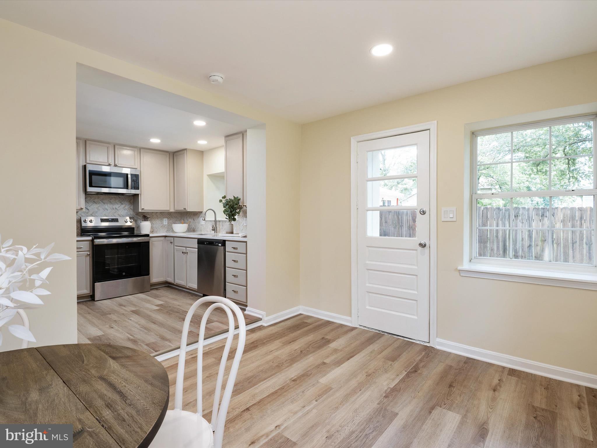 1395 Rainbow Drive Pasadena, MD 21122 - Photo 22 of 28 a kitchen with kitchen island granite countertop wooden floors and stainless steel appliances