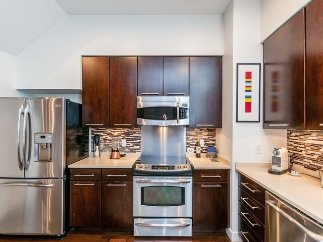 a kitchen with stainless steel appliances granite countertop a stove and a refrigerator