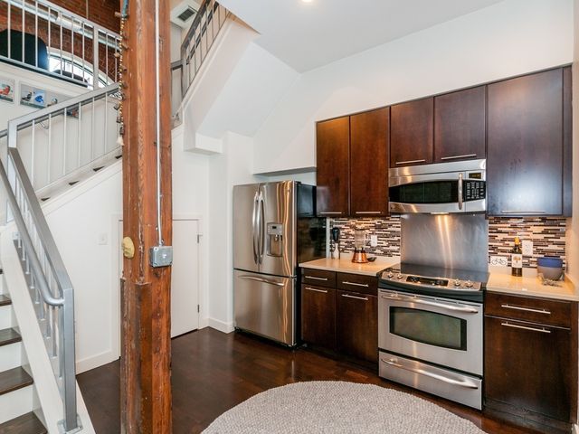 a kitchen with granite countertop stainless steel appliances and wooden cabinets