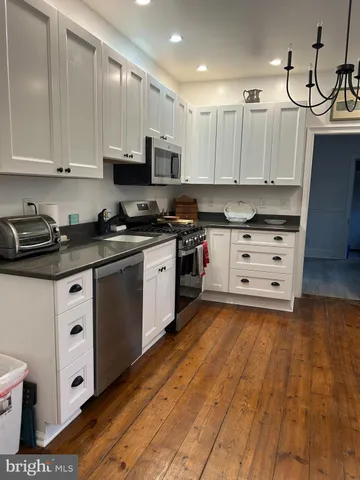 a kitchen with stainless steel appliances a sink a stove a refrigerator and cabinets