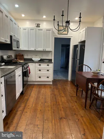 a kitchen with granite countertop a stove a sink and a refrigerator
