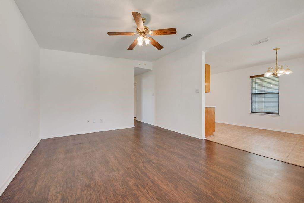 301 Lipscomb Street Cleburne, TX 76031 - Photo 4 of 21 Unfurnished room featuring suspended lighting, dark wood-style floors, and ceiling fan