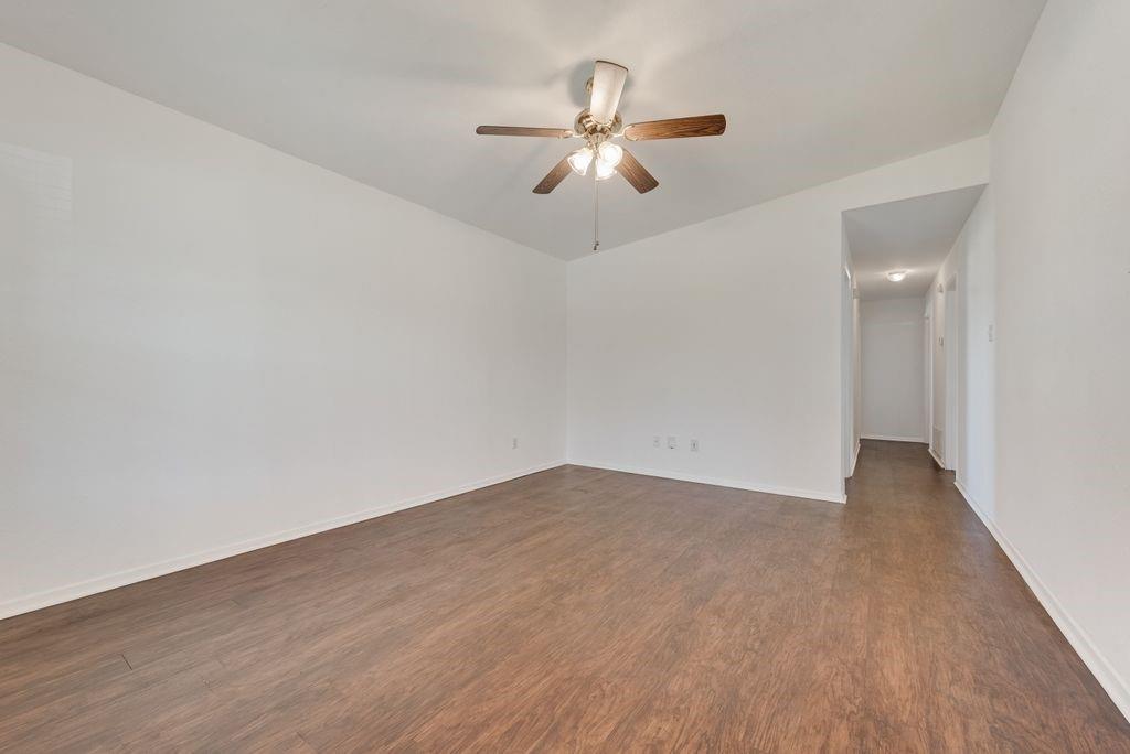 301 Lipscomb Street Cleburne, TX 76031 - Photo 5 of 21 Unfurnished room with dark wood-type flooring and a ceiling fan