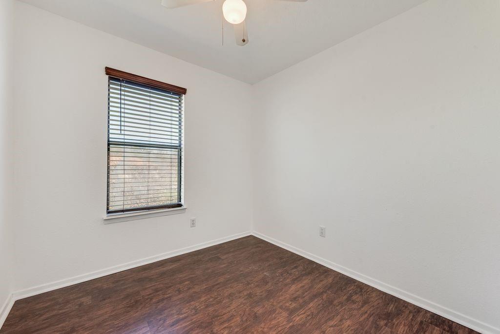 301 Lipscomb Street Cleburne, TX 76031 - Photo 10 of 21 Empty room with baseboards and dark wood-style floors