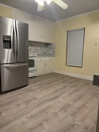 a kitchen with stainless steel appliances granite countertop a refrigerator sink and white cabinets