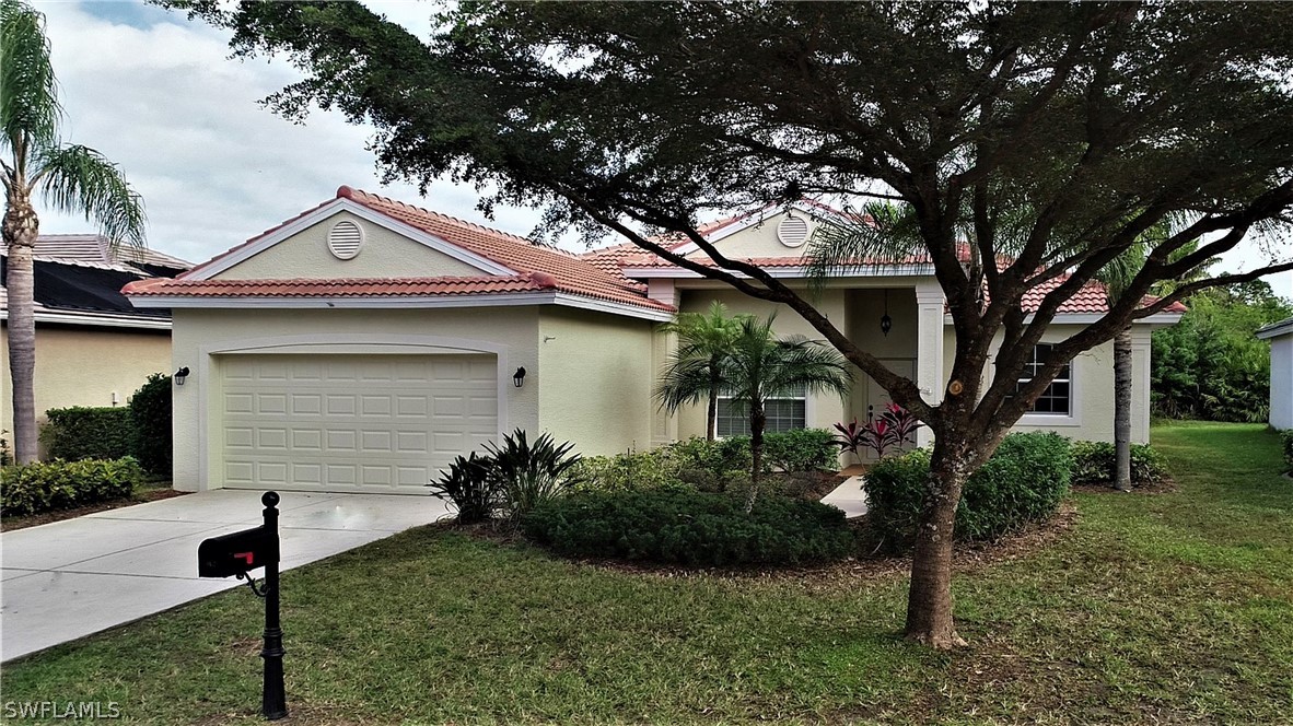 4612 Fairloop Run Lehigh Acres, FL 33973 - Photo 2 of 35 a front view of a house with garden