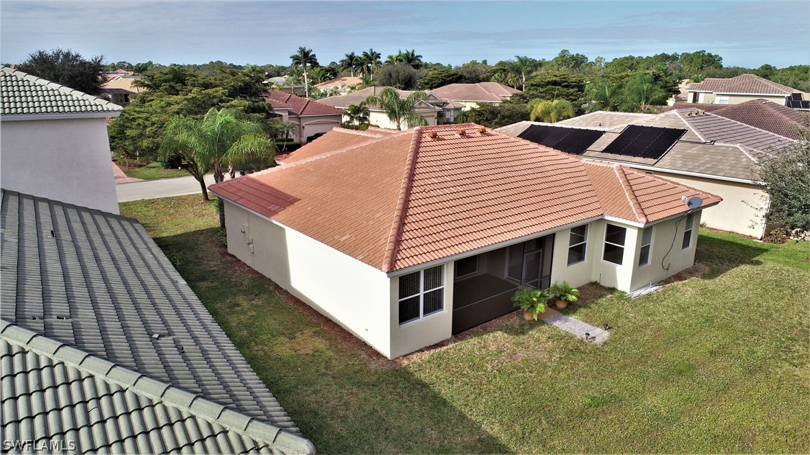 4612 Fairloop Run Lehigh Acres, FL 33973 - Photo 27 of 35 an aerial view of a house with swimming pool and trees all around