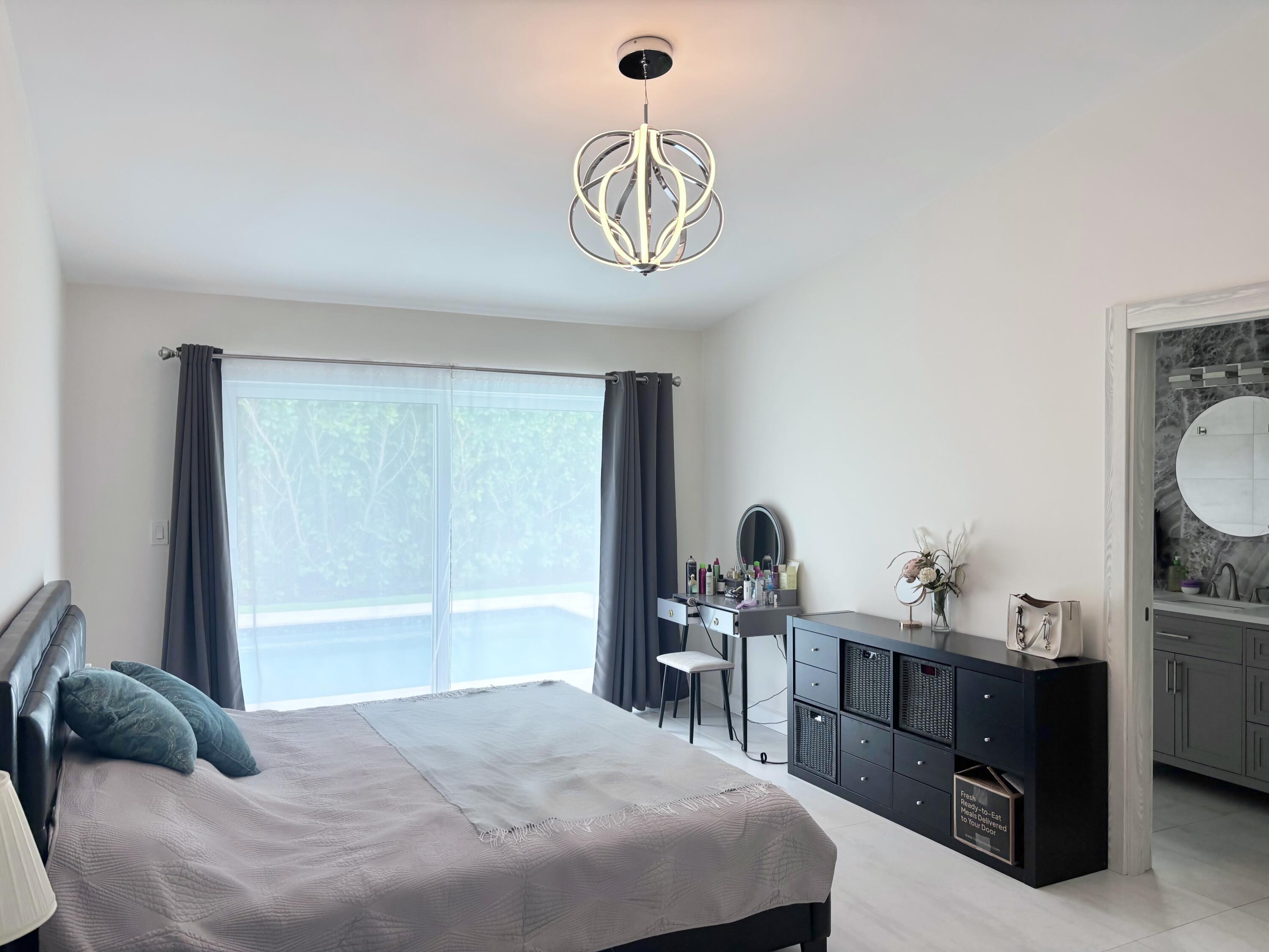 330 Sandalwood Lane Boca Raton, FL 33487 - Photo 11 of 23 a bedroom with a bed and a chandelier