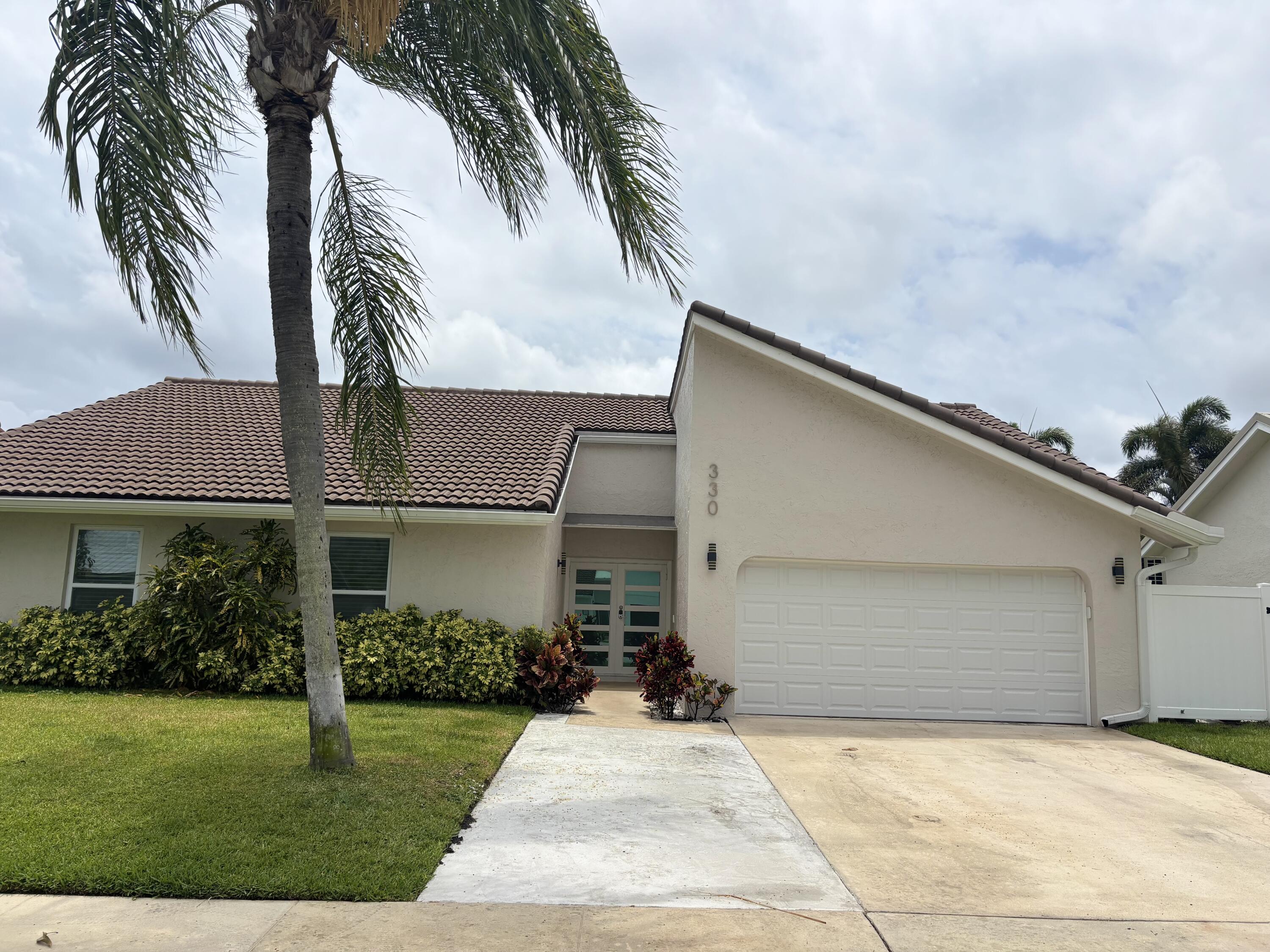 330 Sandalwood Lane Boca Raton, FL 33487 - Photo 22 of 23 a front view of a house with a garden