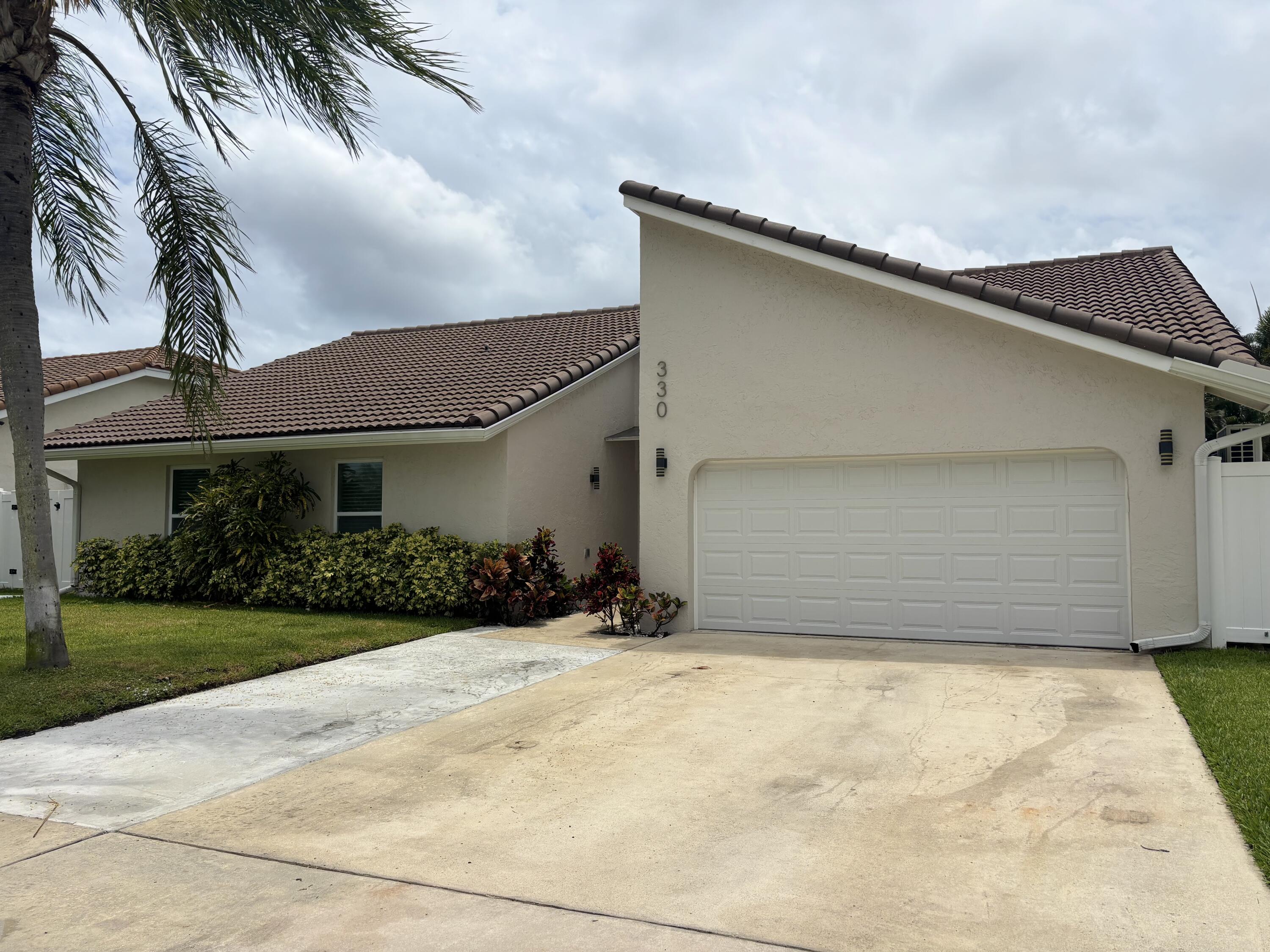 330 Sandalwood Lane Boca Raton, FL 33487 - Photo 23 of 23 a front view of a house with a yard