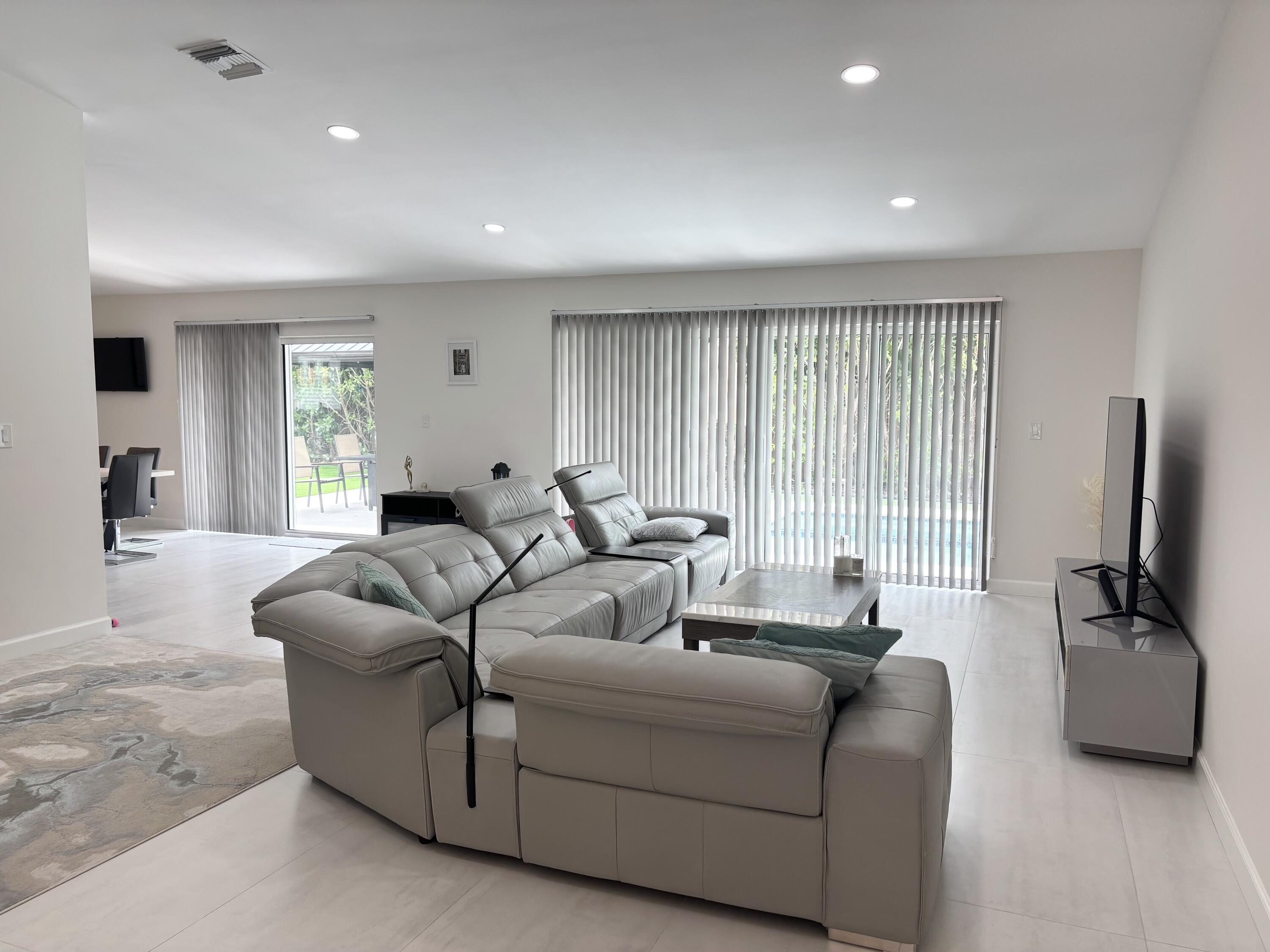 330 Sandalwood Lane Boca Raton, FL 33487 - Photo 7 of 23 a living room with furniture a large window and a wooden floor