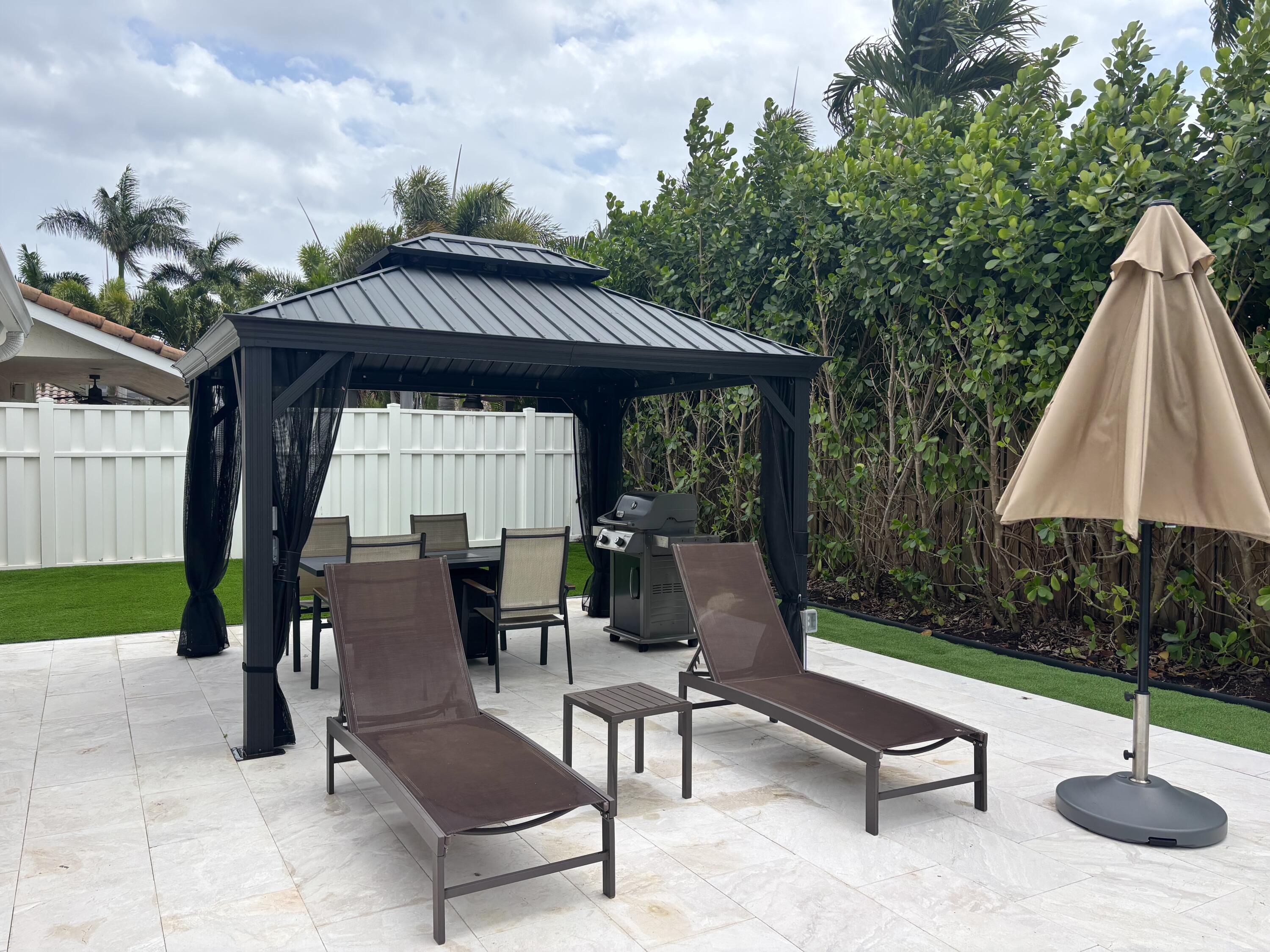 330 Sandalwood Lane Boca Raton, FL 33487 - Photo 10 of 23 a view of a patio with a table chairs and a yard