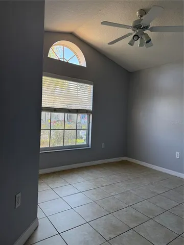 an empty room with windows and fan