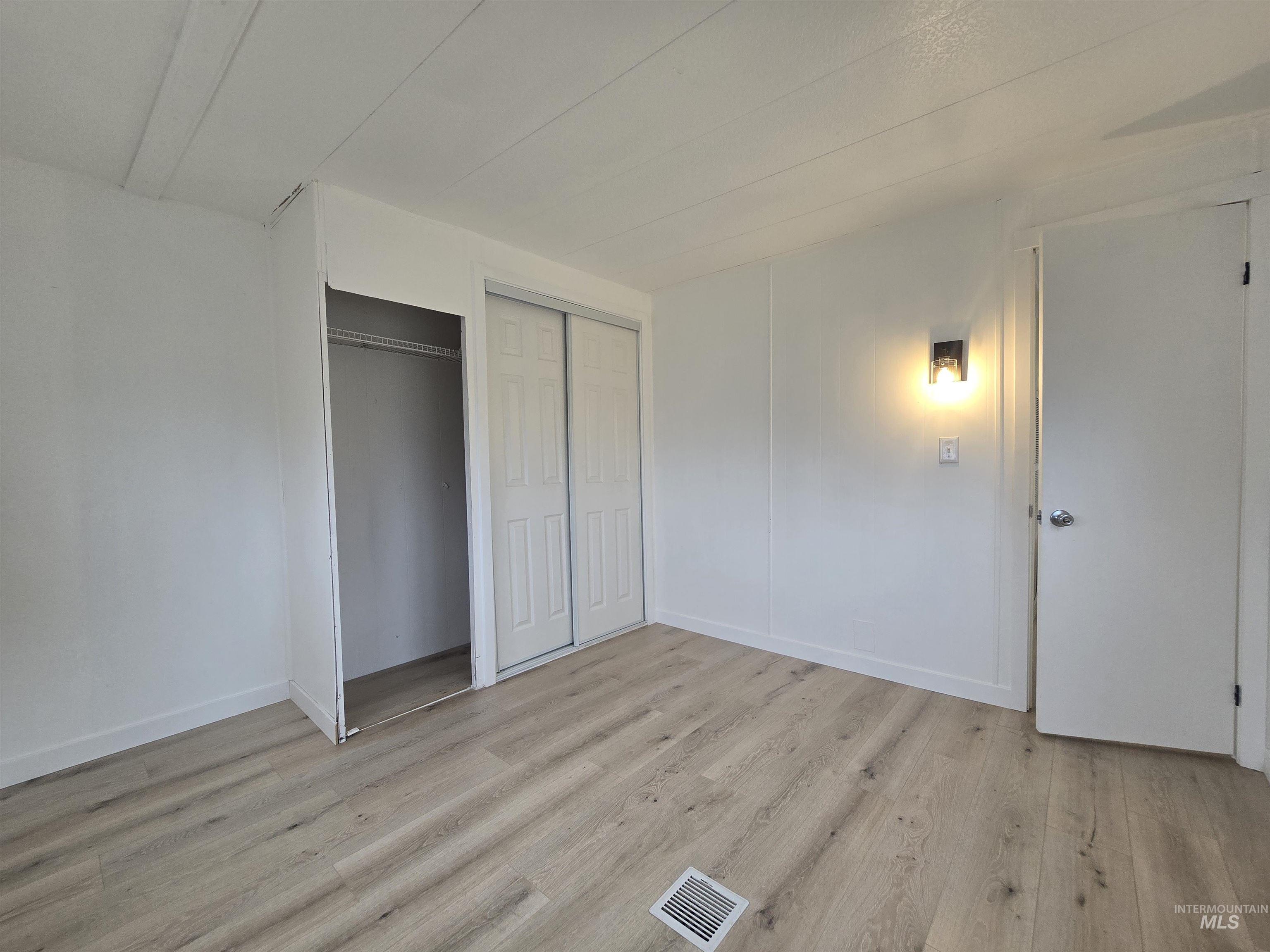 915 South Curtis Road, Unit 80 Boise, ID 83705 - Photo 8 of 12 Unfurnished bedroom featuring light wood finished floors and a closet