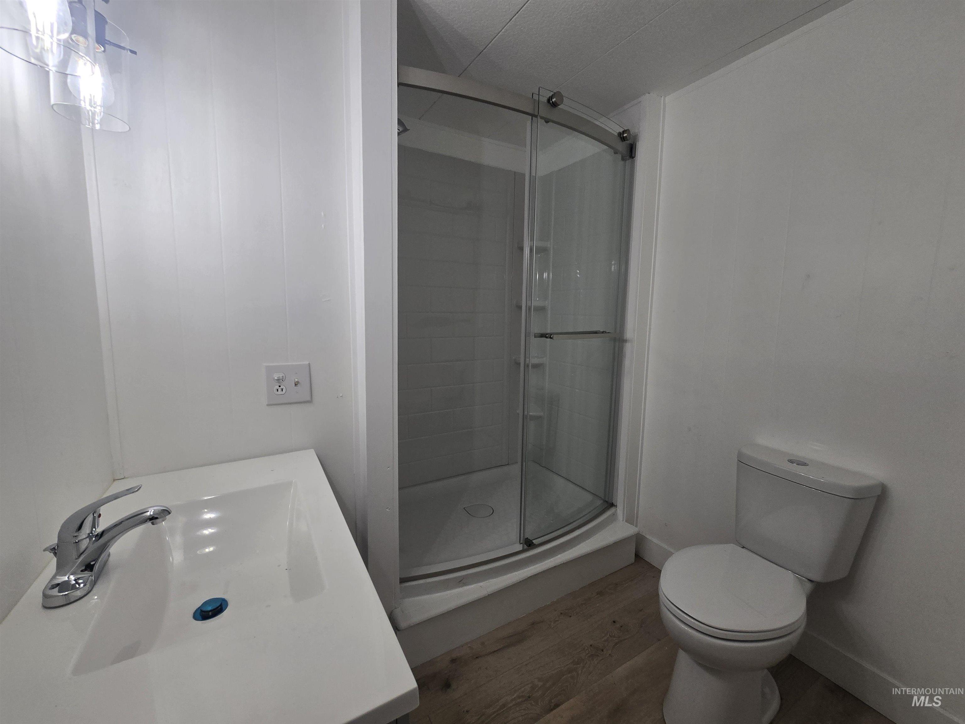 915 South Curtis Road, Unit 80 Boise, ID 83705 - Photo 9 of 12 Full bath featuring a shower stall, vanity, and light wood-style flooring