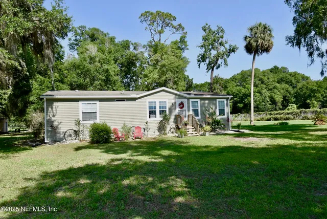 a front view of house with a garden and trees