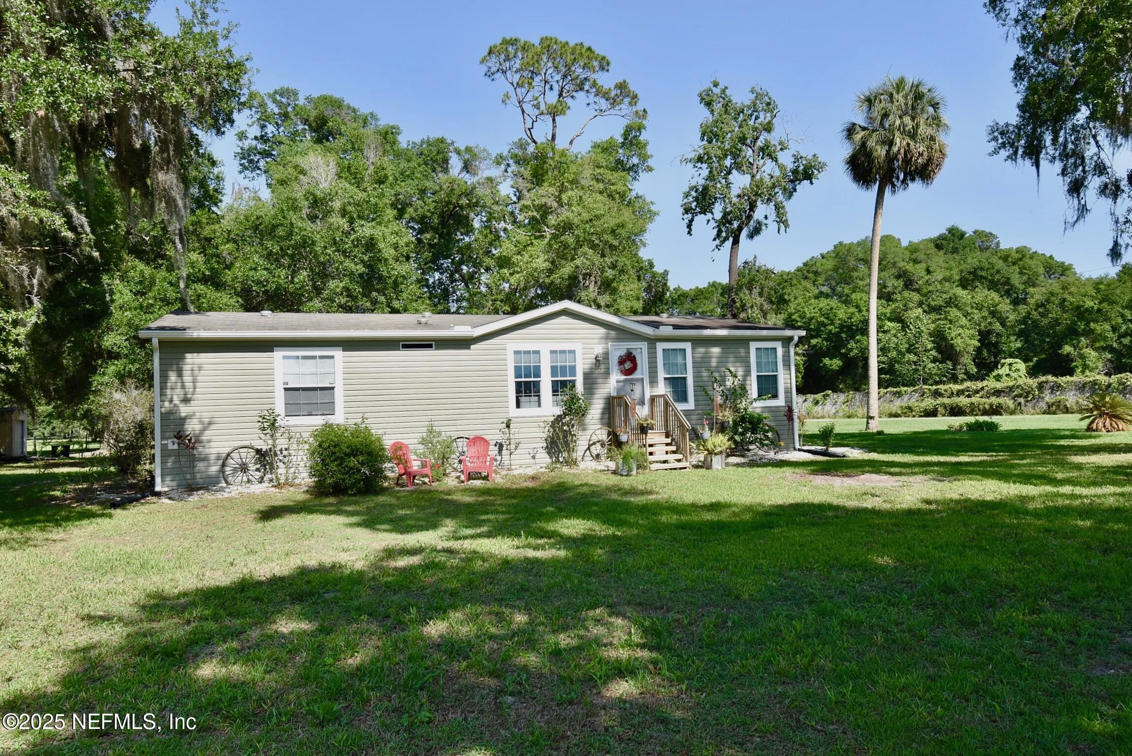 a front view of house with a garden and trees