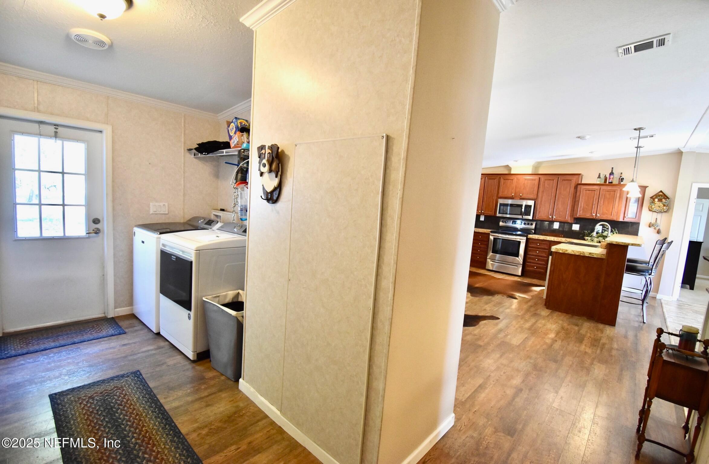 500 Georgetown Shortcut Road Georgetown, FL 32139 - Photo 49 of 59 a kitchen with stainless steel appliances a stove top oven a sink a refrigerator white cabinets and wooden floor