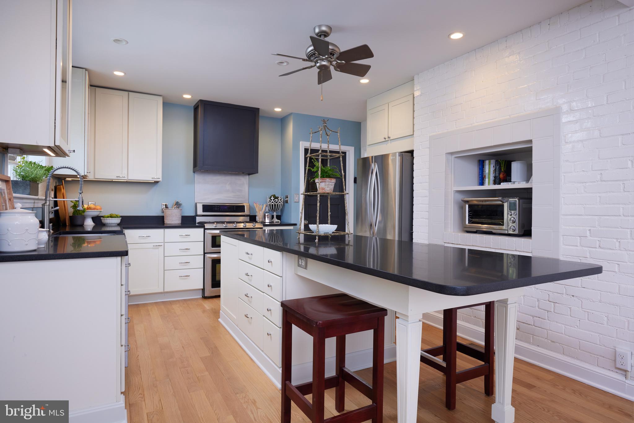 9604 Old Spring Road Kensington, MD 20895 - Photo 17 of 80 a kitchen with stainless steel appliances kitchen island granite countertop a stove a sink and a refrigerator