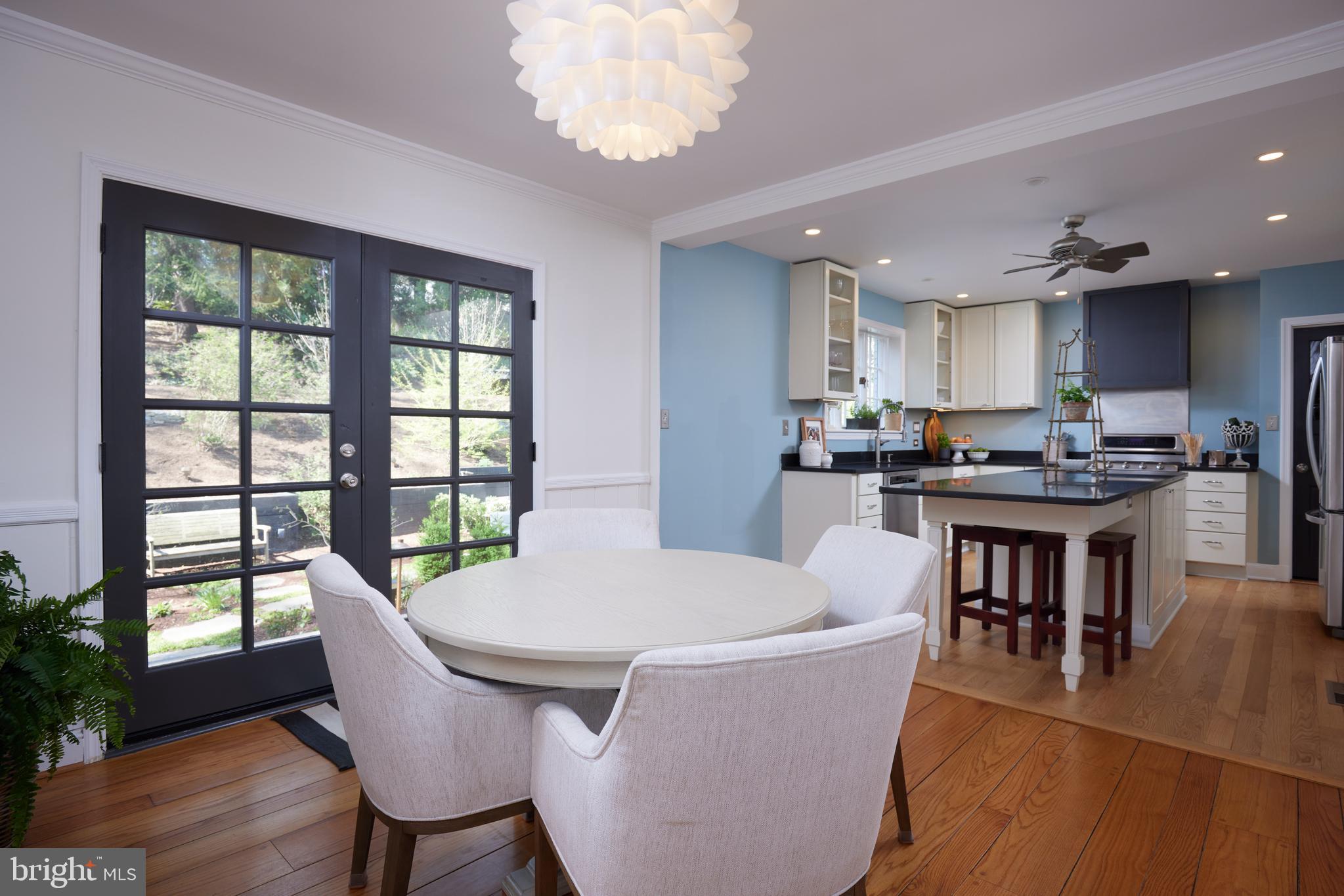9604 Old Spring Road Kensington, MD 20895 - Photo 18 of 80 a dining room with kitchen island stainless steel appliances furniture a large window and kitchen view