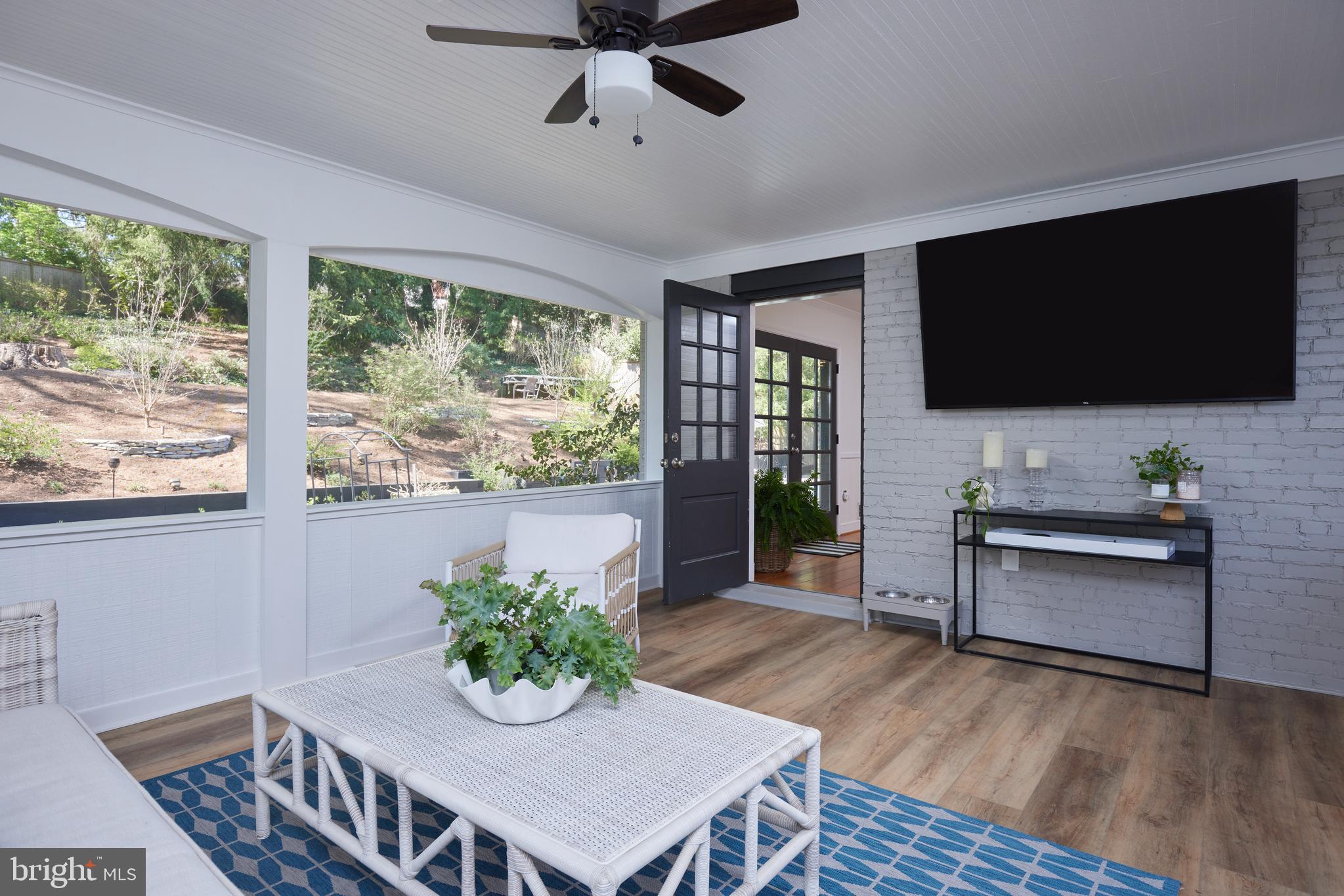 9604 Old Spring Road Kensington, MD 20895 - Photo 21 of 80 a living room with furniture a flat screen tv and a floor to ceiling window