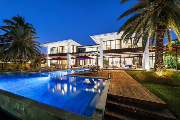 a view of a house with swimming pool and sitting area