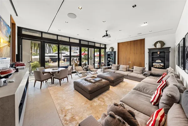 a kitchen with stainless steel appliances kitchen island granite countertop a refrigerator a sink a stove and a dining table with wooden floor