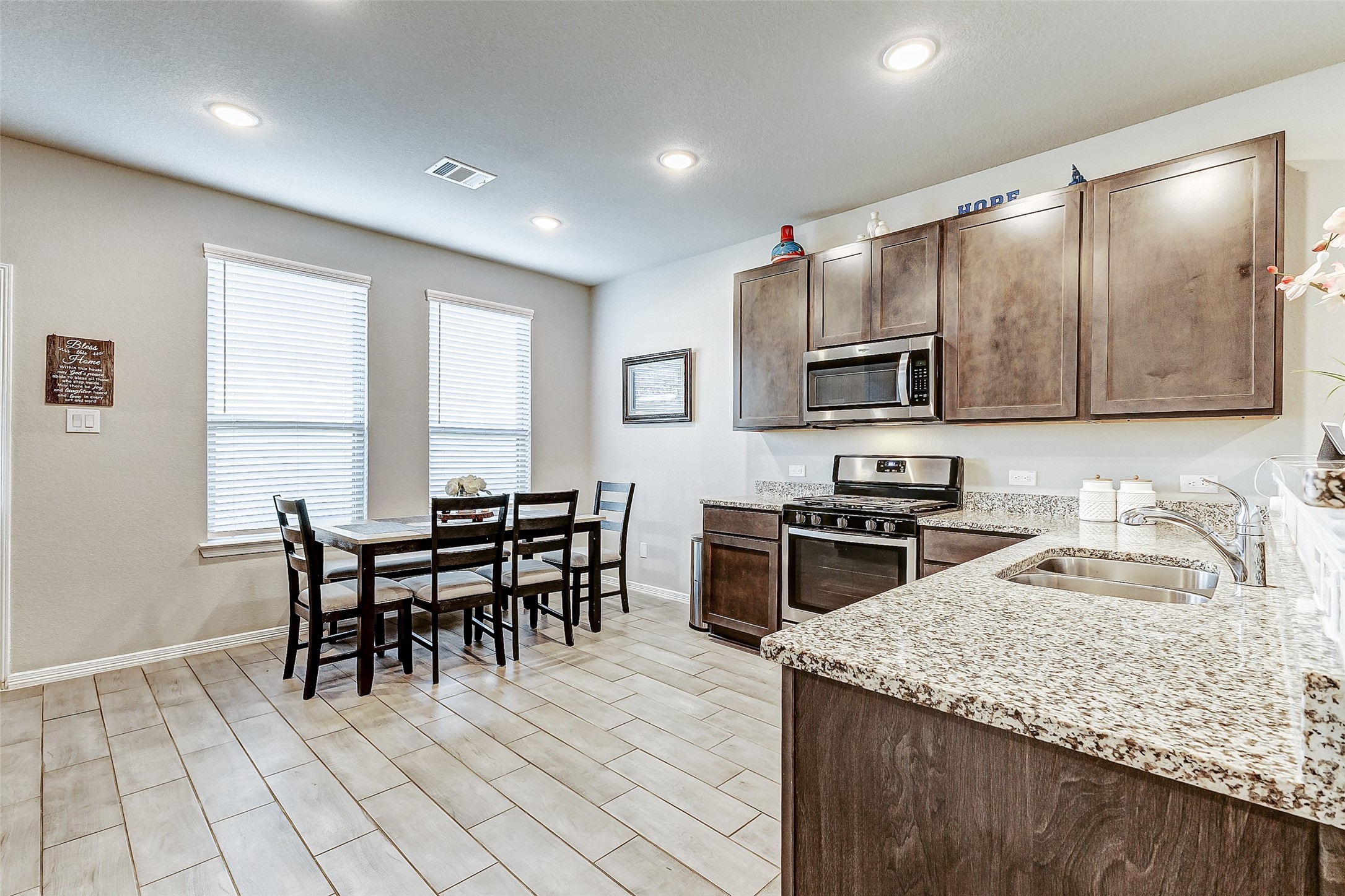 24715 Russet Bluff Trail Houston, TX 77336 - Photo 20 of 31 a kitchen with stainless steel appliances granite countertop a stove a sink a microwave a dining table and chairs