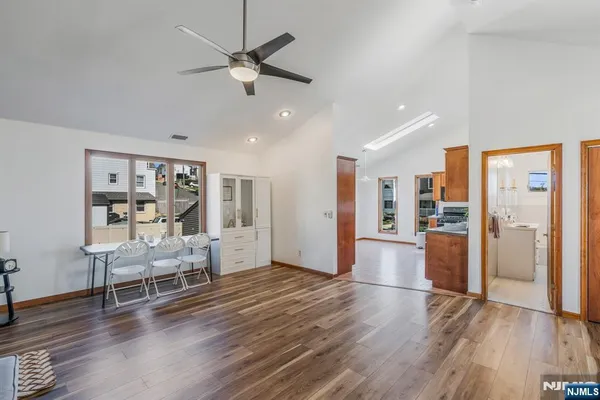 a view of a livingroom with furniture a ceiling fan and wooden floor