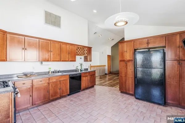 a kitchen with stainless steel appliances granite countertop a refrigerator and a stove top oven