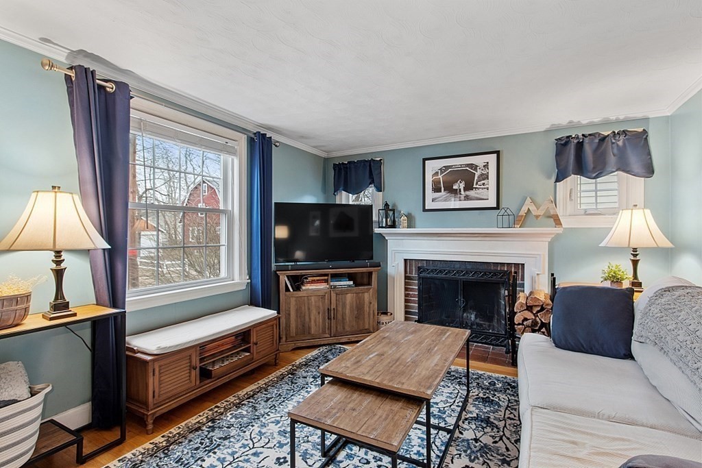 8 Gardner Road Reading, MA 01867 - Photo 3 of 35 a living room with furniture a flat screen tv and a fireplace