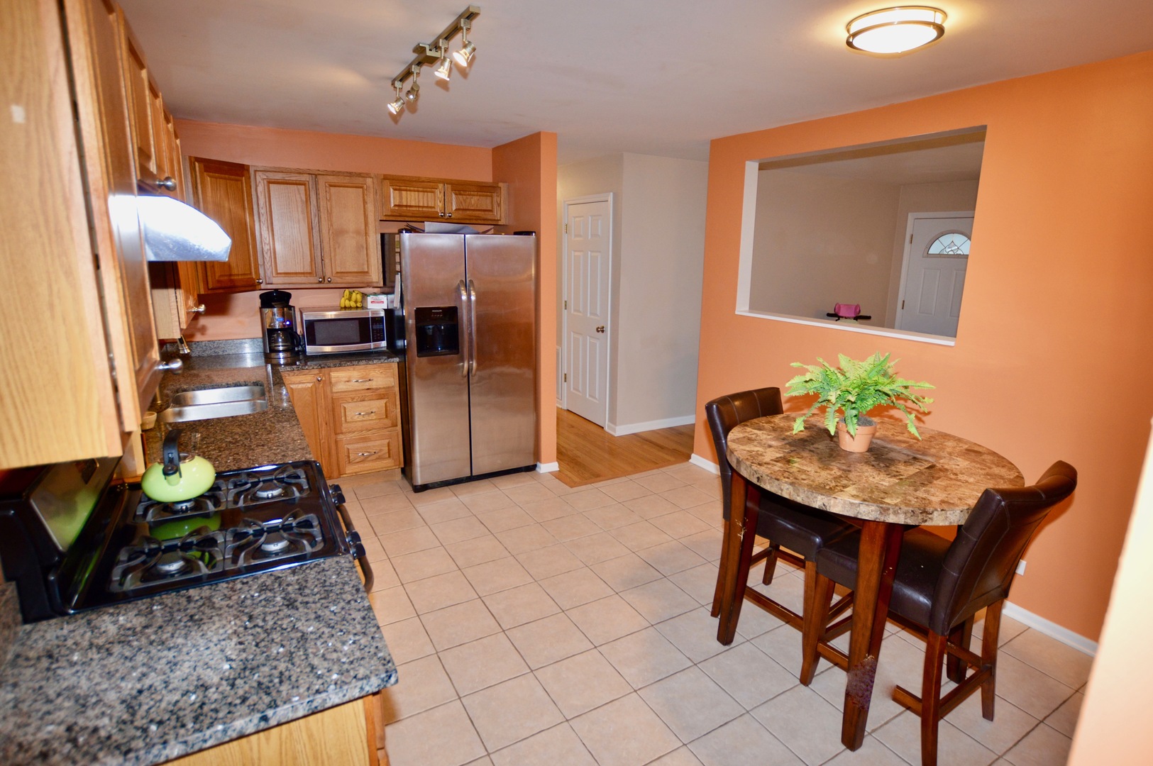 385 Willow Road Wauconda, IL 60084 - Photo 3 of 22 a kitchen with stainless steel appliances granite countertop table chairs and a refrigerator