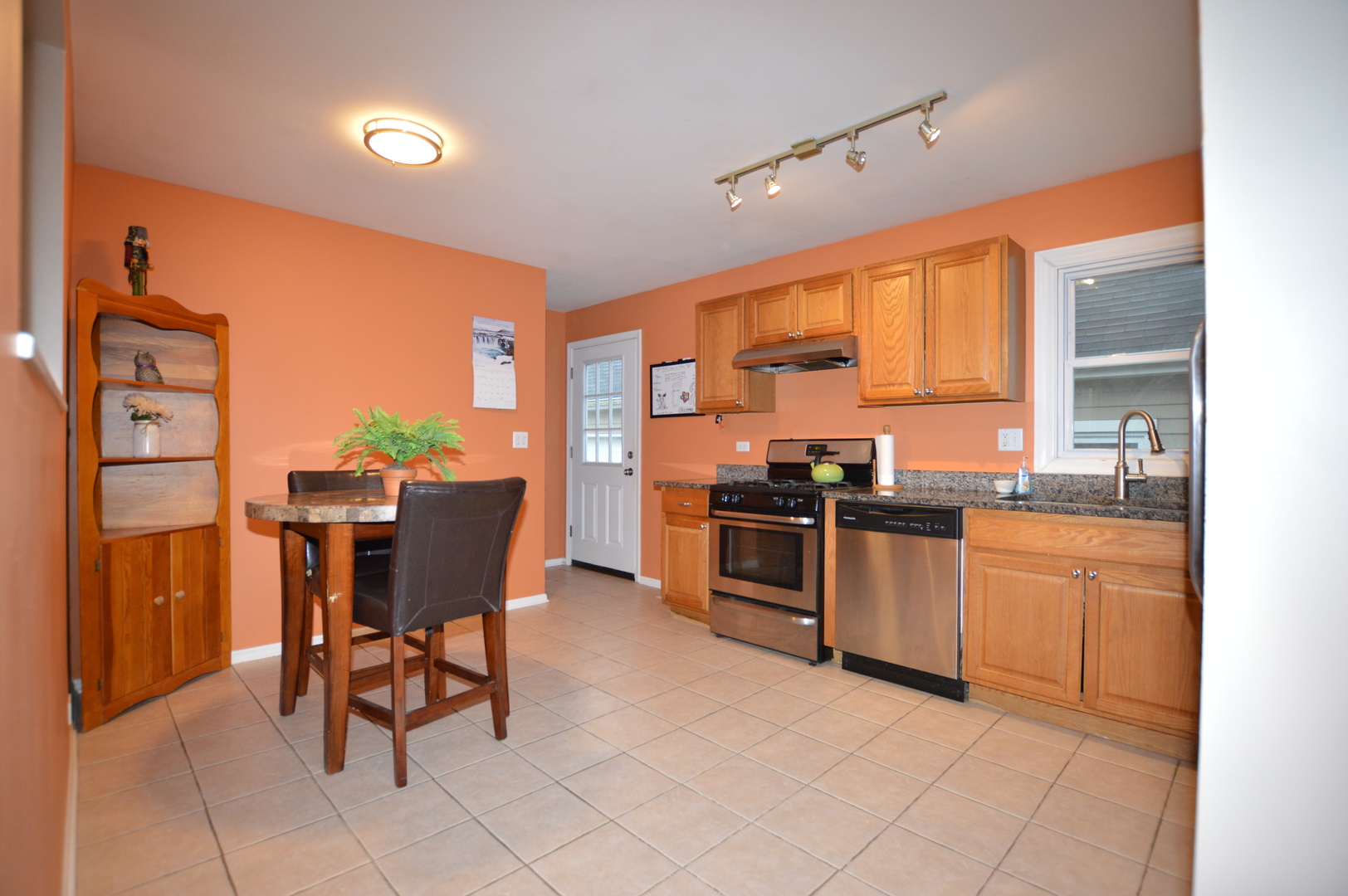 385 Willow Road Wauconda, IL 60084 - Photo 5 of 22 a kitchen with stainless steel appliances granite countertop a stove top oven a sink a dining table and chairs with the view of cabinet