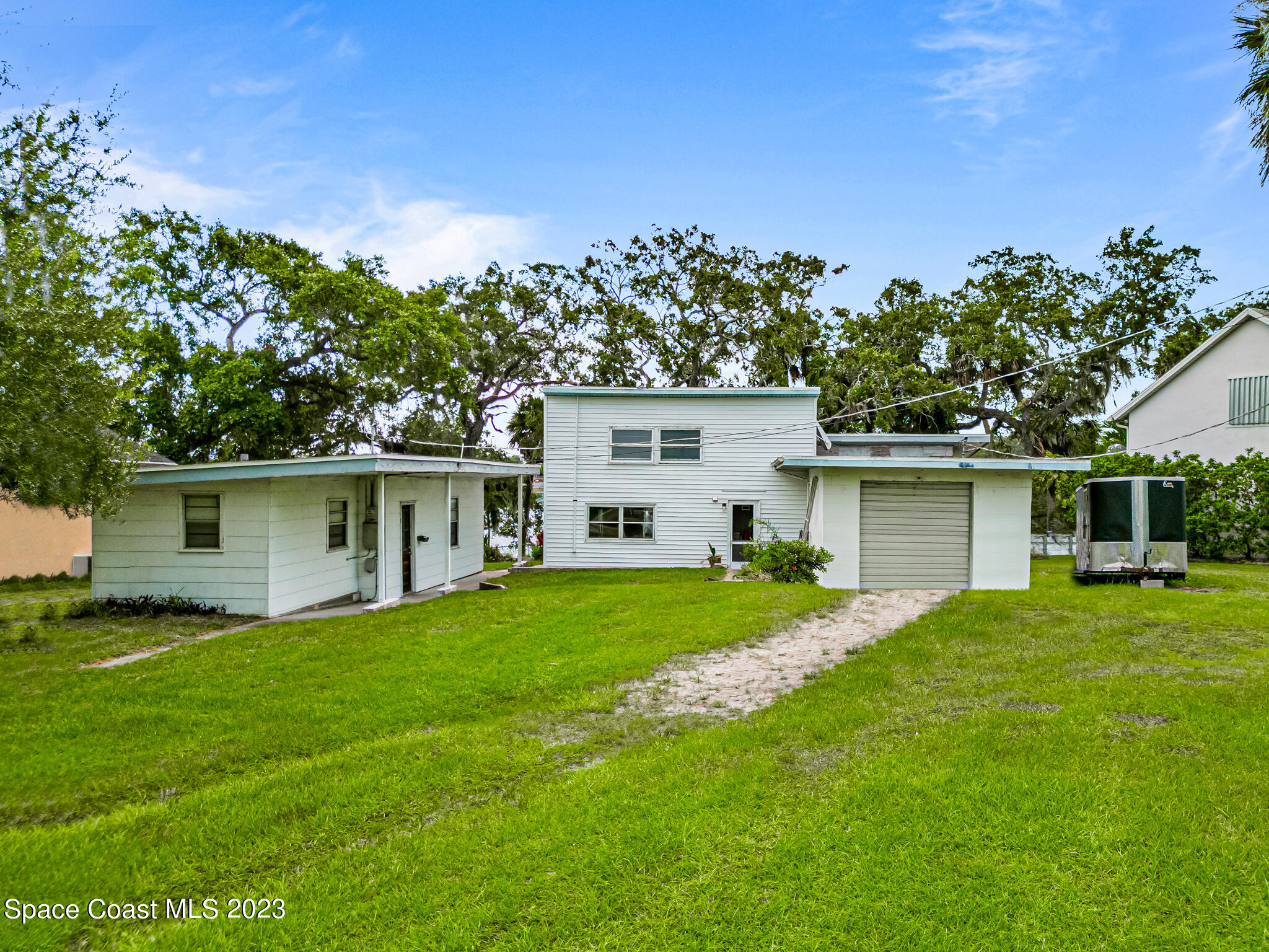 877 Sunset Drive Melbourne, FL 32935 - Photo 2 of 49 a front view of house with yard and trees in the background