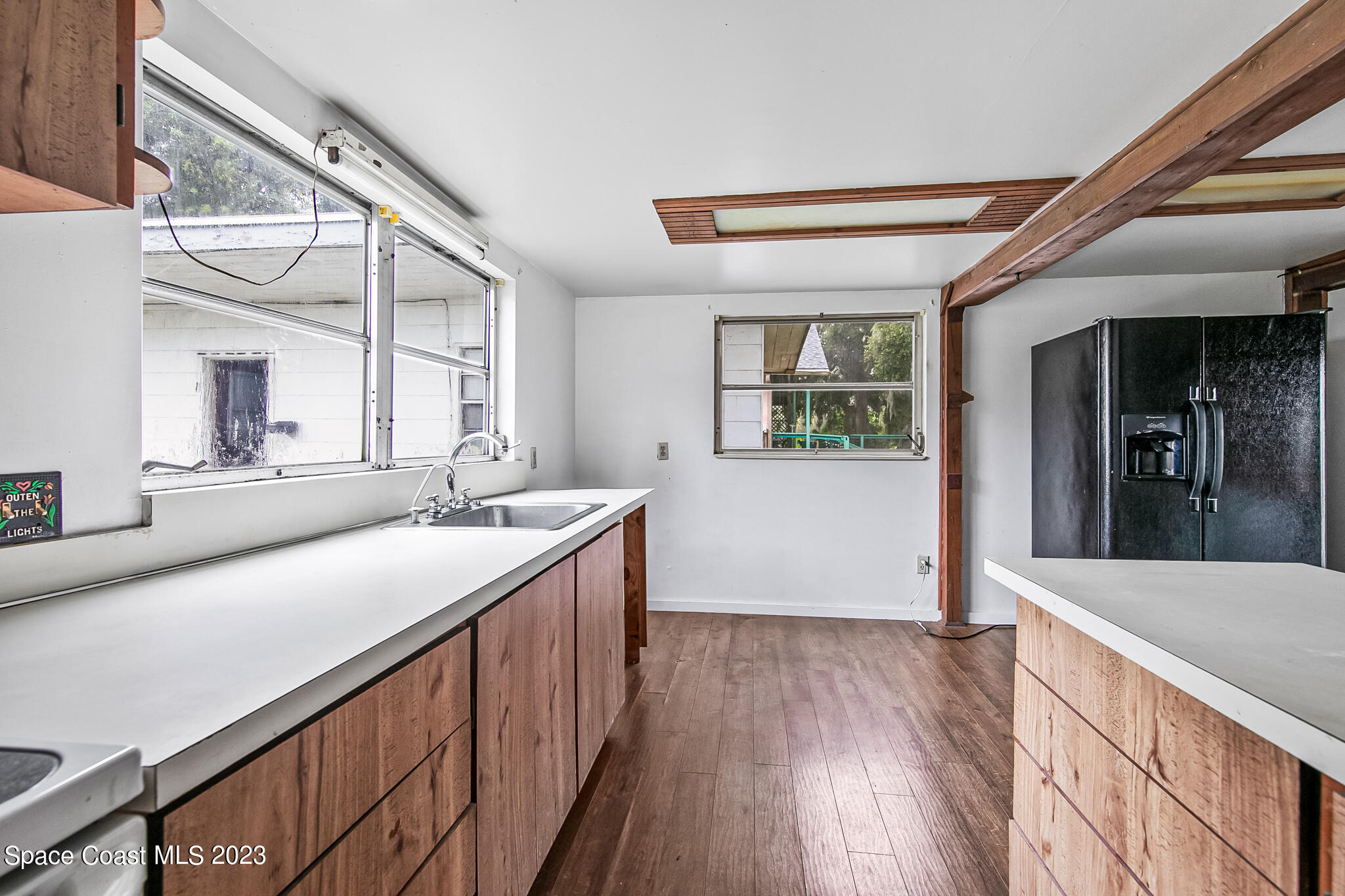 877 Sunset Drive Melbourne, FL 32935 - Photo 32 of 49 a kitchen with a sink and wooden floor